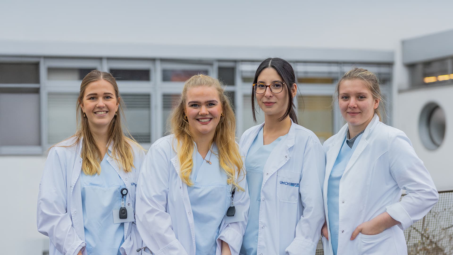 Vier Medizinstudierende des UMFST-UMCH in Laborkitteln auf dem Campus